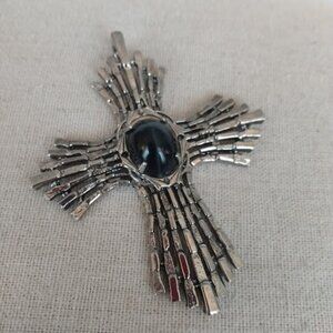 Brutalist style silver tone metal cross pendant with center stone.